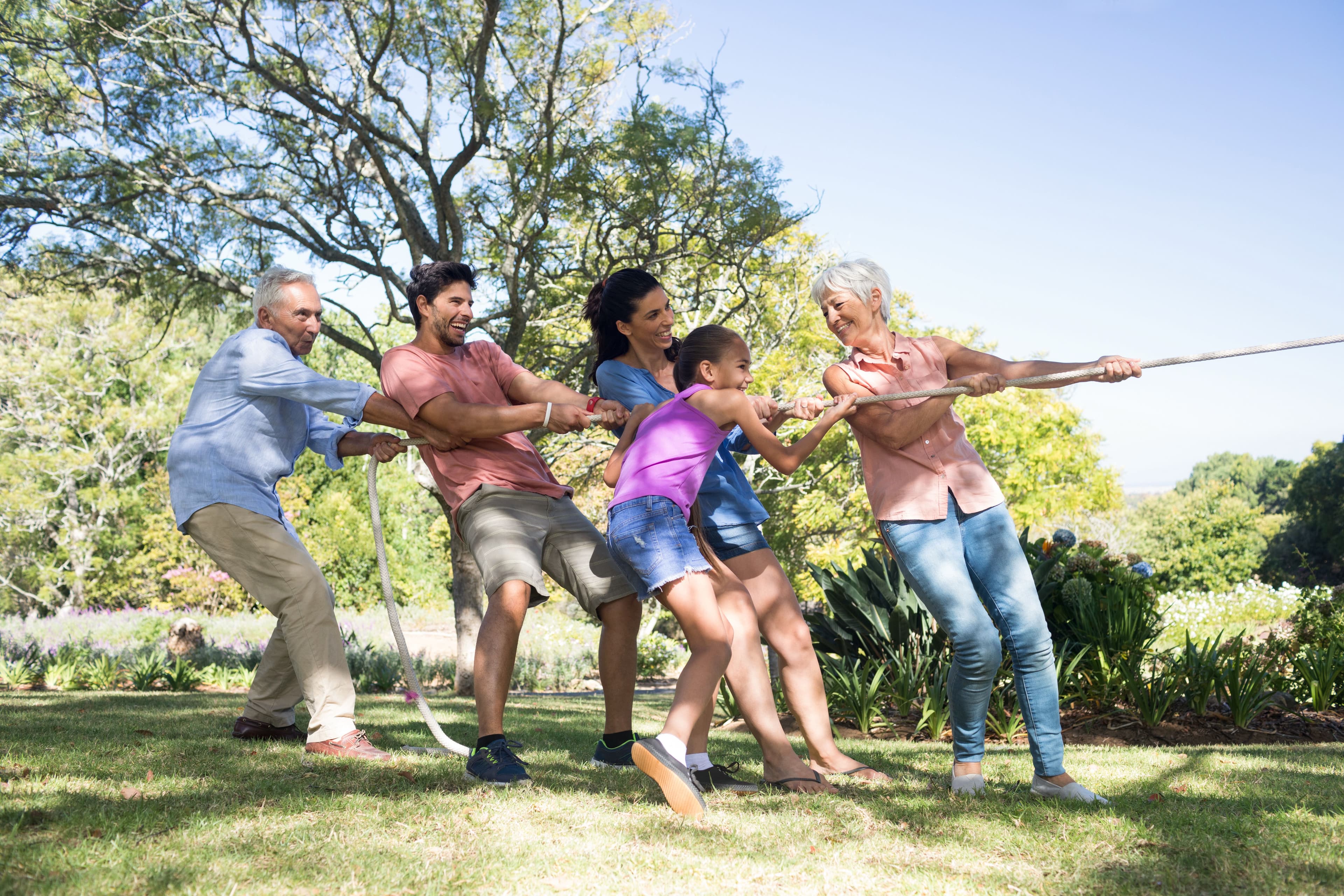 Five family members playing tug-of-war on a successfully planned family reunion.