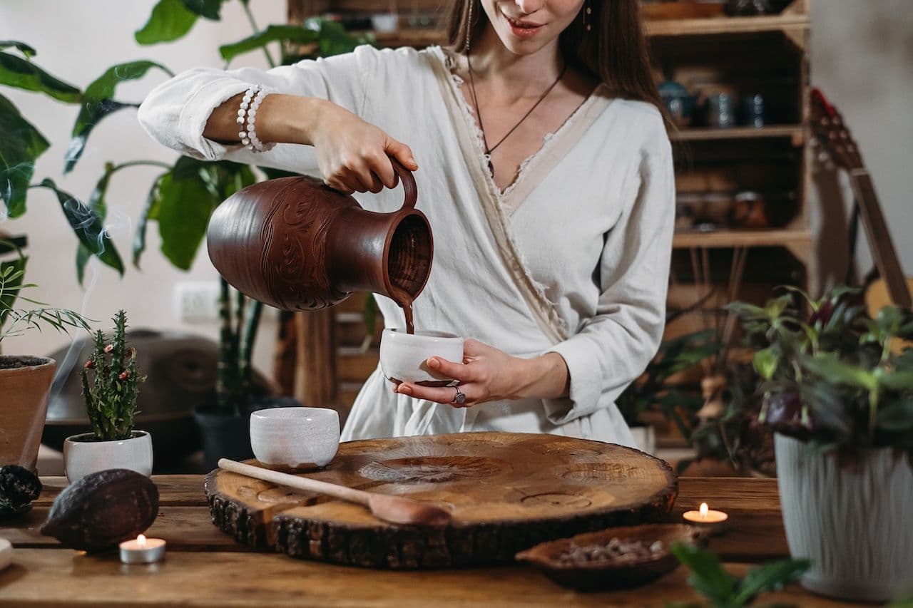 women pouring ceremonial cacao into cup teaching benefits of ceremonial cacao