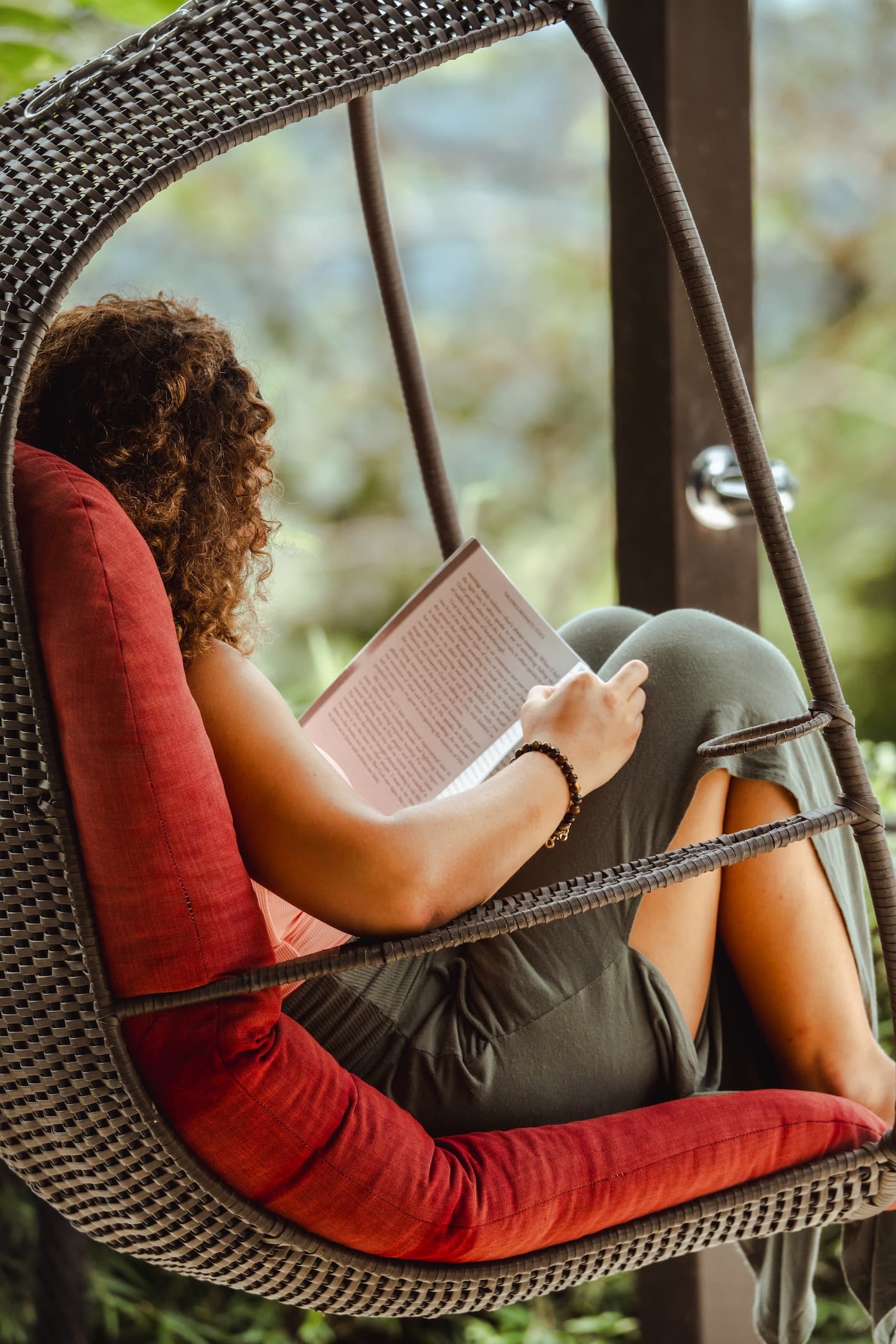 A woman reading in a chair at a relaxed corporate retreat setting, unlike the chaotic Plex corporate retreat.