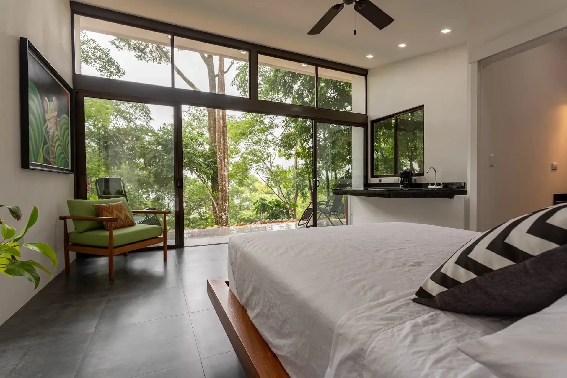 Modern villa bedroom with floor-to-ceiling jungle views at Vajra Jahra Retreat Center, a Costa Rica retreat center.