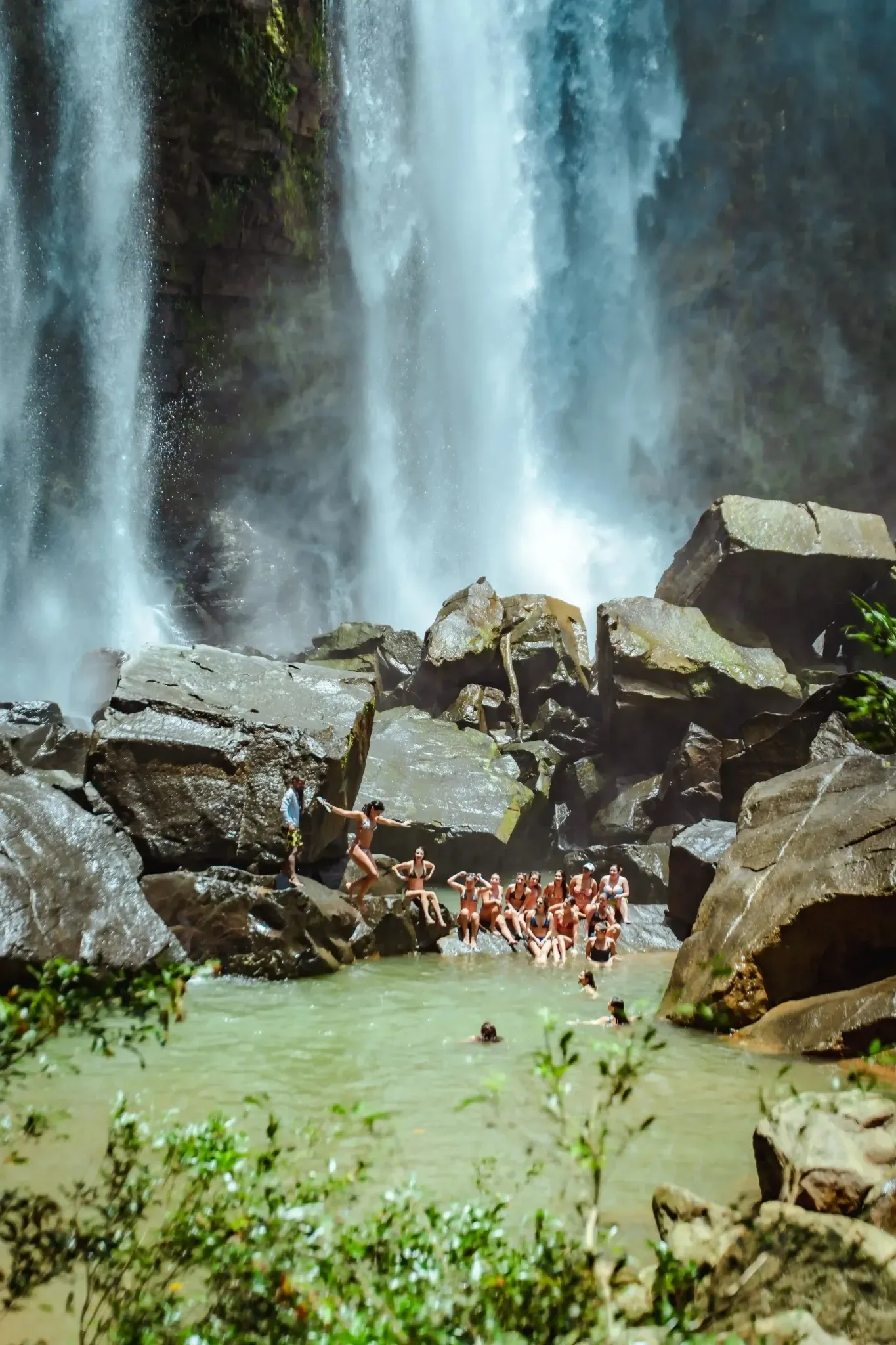 Guests gathering at the base of a powerful waterfall on a Vajra Jahra Retreat Center outing, elevating the retreat experience beyond an airbnb dominical costa rica.