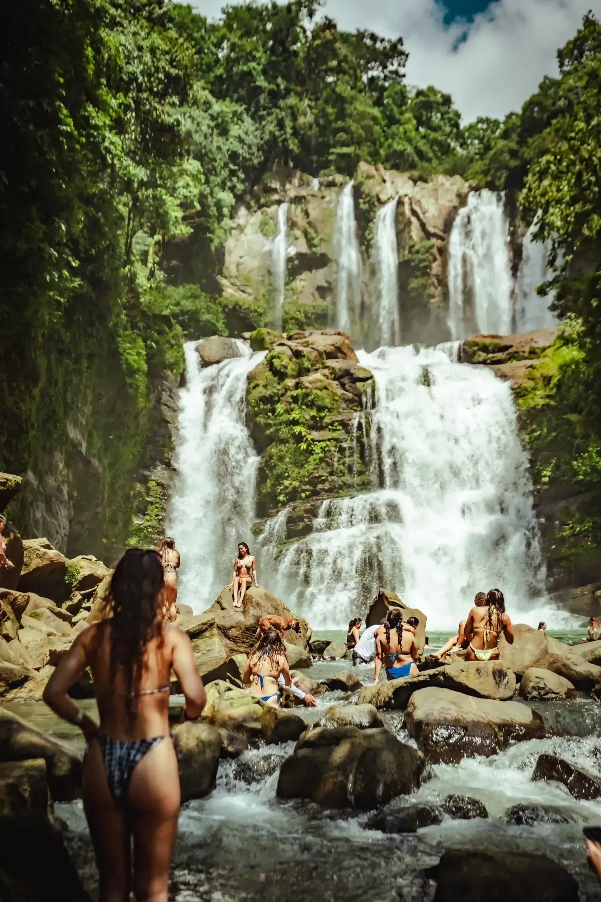 People enjoying the natural pools and cascading waterfalls close to Vajra Jahra Retreat Center, an immersive Costa Rica retreat center surrounded by jungle.