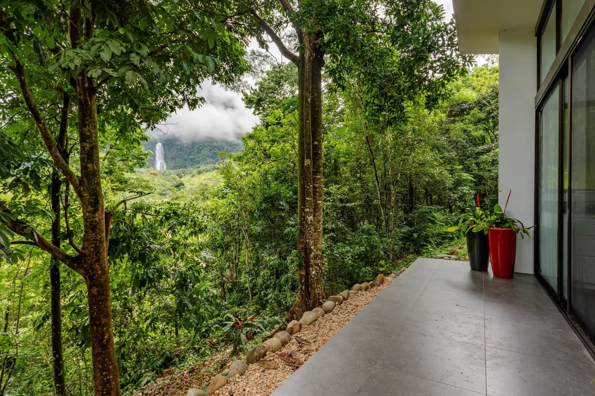 View of the jungle and Diamante Waterfall from a villa terrace at Vajra Jahra Retreat Center, offering a peaceful retreat Costa Rica setting surrounded by nature.