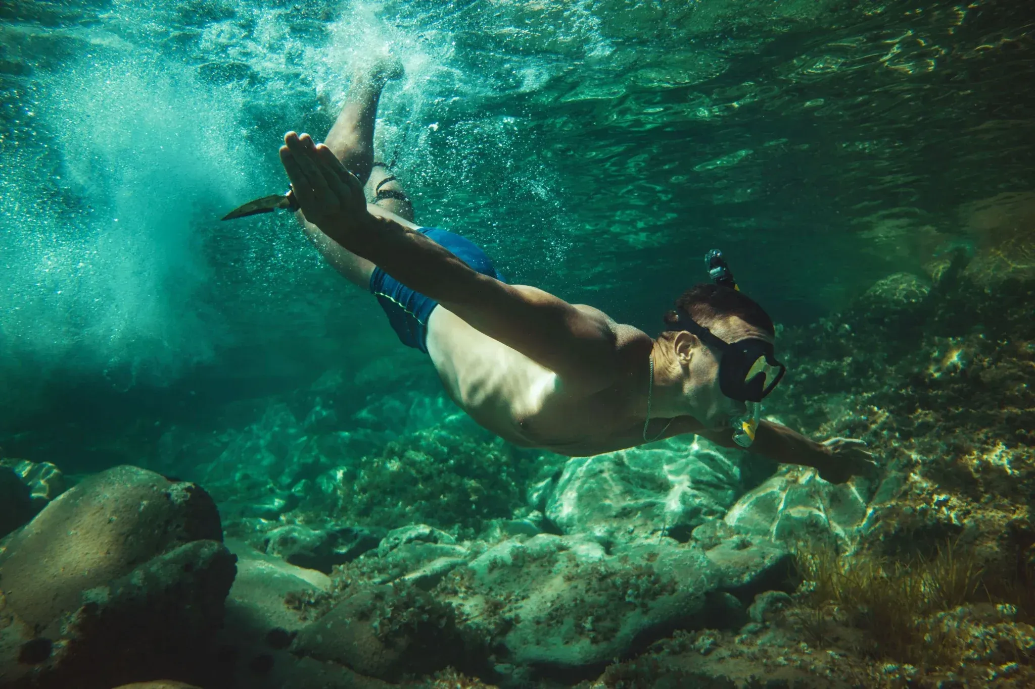 Person snorkeling through clear turquoise water near Vajra Jahra Retreat Center, capturing the adventurous side of Costa Rica Yoga Teacher Training.