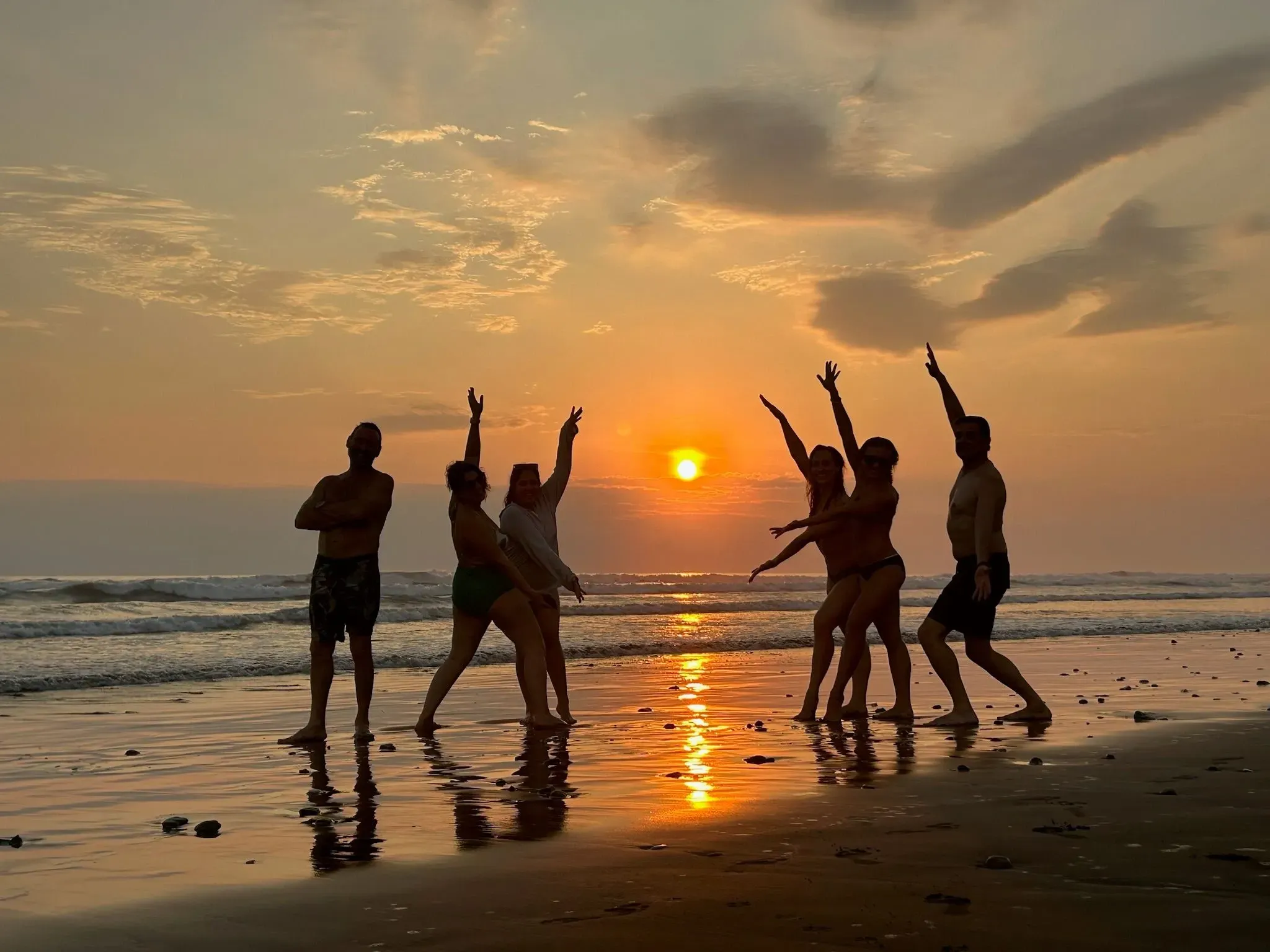 Guests enjoying a playful sunset moment on the beach near Vajra Jahra Retreat Center, a scenic and nature-rich choice among top Costa Rica wedding venues.