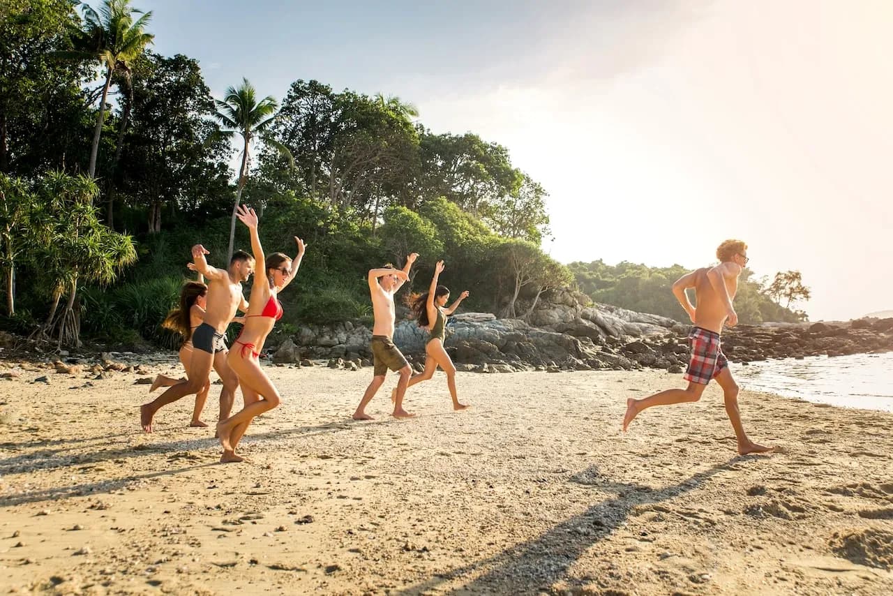 Group running down the beach into the ocean on a leadership retreat.