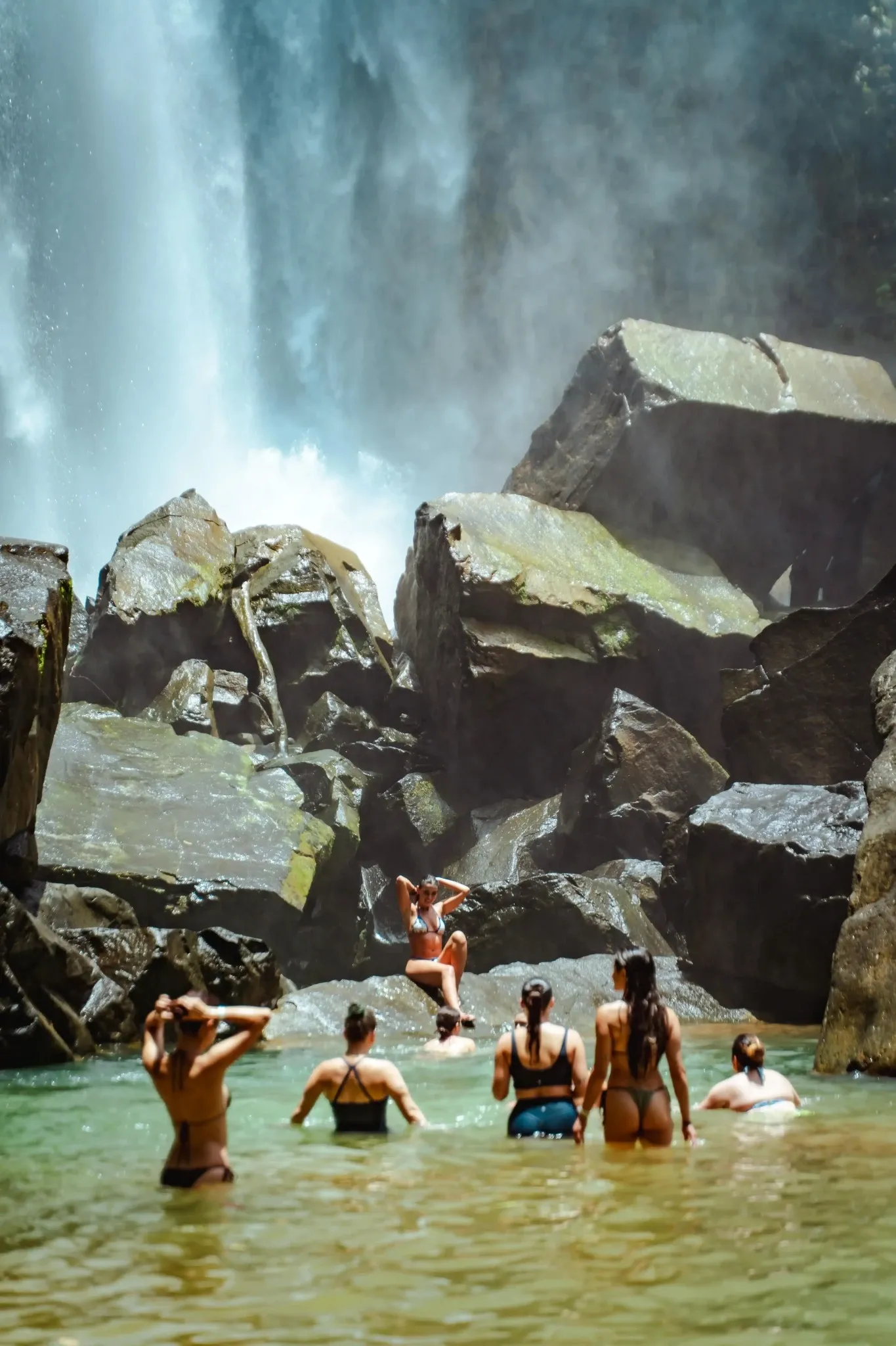 Guests enjoying a natural waterfall pool close to Vajra Jahra Retreat Center, a scenic adventure included in a Yoga Retreat in Costa Rica.