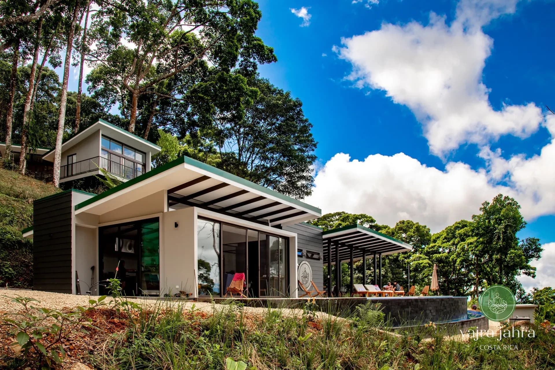 Main building and villas at Vajra Jahra, a luxury Costa Rica retreat center surrounded by lush jungle and blue skies.